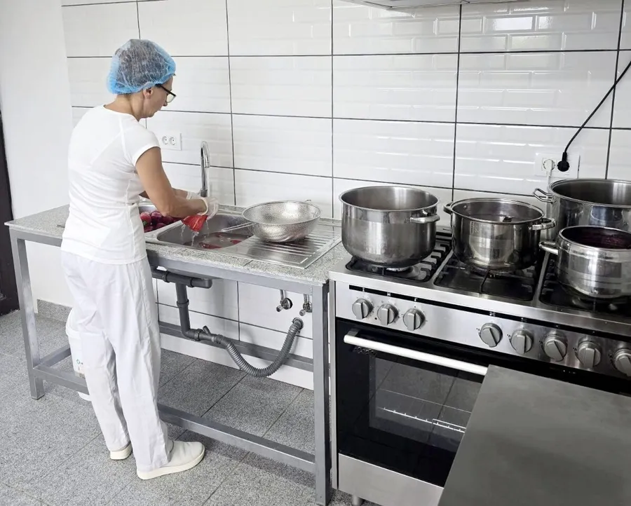 Mirela Andrei spală fructe în atelierul unde se prepară dulcețuri Bunătăți din Pleșești