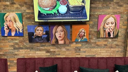 Restaurantul ”Trattoria Meloni”, al fiului unui actor celebru, deschis în Albania în faţa unei tabere de migranţi arestaţi în apele italiene / Clienţii mănâncă peşte şi fructe de mare ”priviţi” de 70 de portrete ale şefei extreme drepte italiene