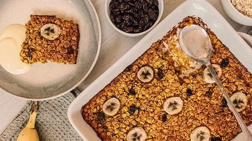 O idee de mic dejun cald din fulgi de ovăz cu turmeric și stafide, gătit la cuptor, servit cu fructe la alegere