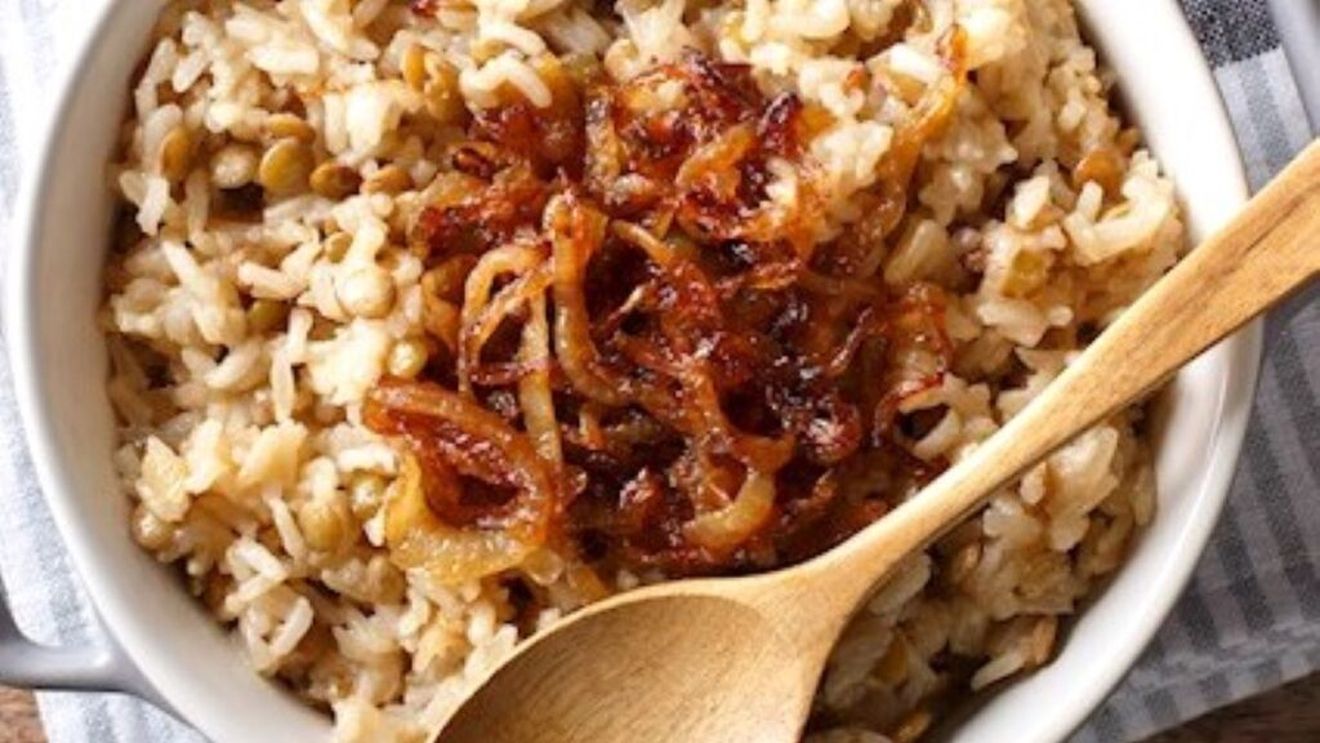 Mâncare orientală plină de arome din linte și orez, cu ceapă caramelizată deasupra. Se numește mujaddara și aparține bucătăriei Orientului Mijlociu