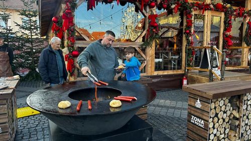La Târgul de Crăciun de la Sibiu poți să îți prăjești singur cârnații pe o plită încălzită cu lemne