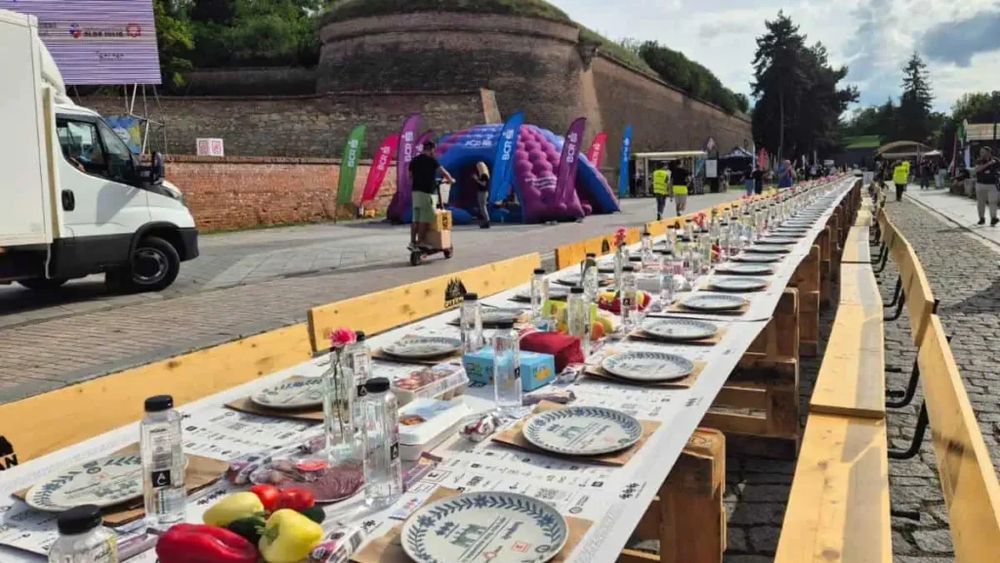 VIDEO | Masa care unește: Alba Iulia a stabilit sâmbătă, pentru a treia oară, un nou record mondial, cu cea mai lungă masă din materiale reciclabile din lume / 10.000 de oameni au participat la ospățul record