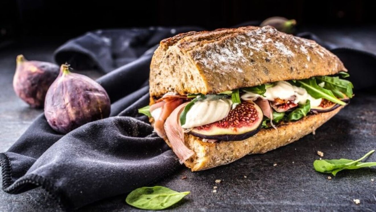 Sandviș cu prosciutto și smochine, brânză Brie și rucola. O idee de mic dejun care poate fi și un prânz la pachet sau o cină rapidă