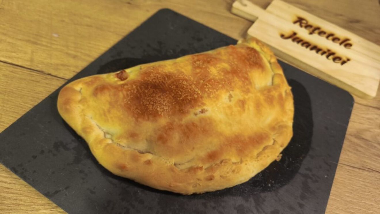 FOTO | Calzone clasic, vărul apropiat al pizzei/ Cum îl pregătești și care e povestea din spatele acestui preparat/ Rețetă de calzone cu șuncă, guanciale, mozzarella și ceapă și porumb