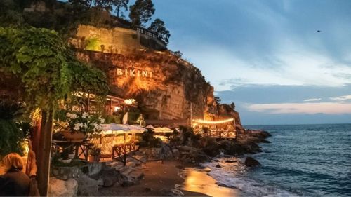Povestea restaurantului Il Bikini, din apropiere de Napoli, desemnat de ghidul Michelin cel mai atrăgător local la malul mării. Inaugurat în 1952, este construit la baza unei stânci și are alături și o plajă exclusivă