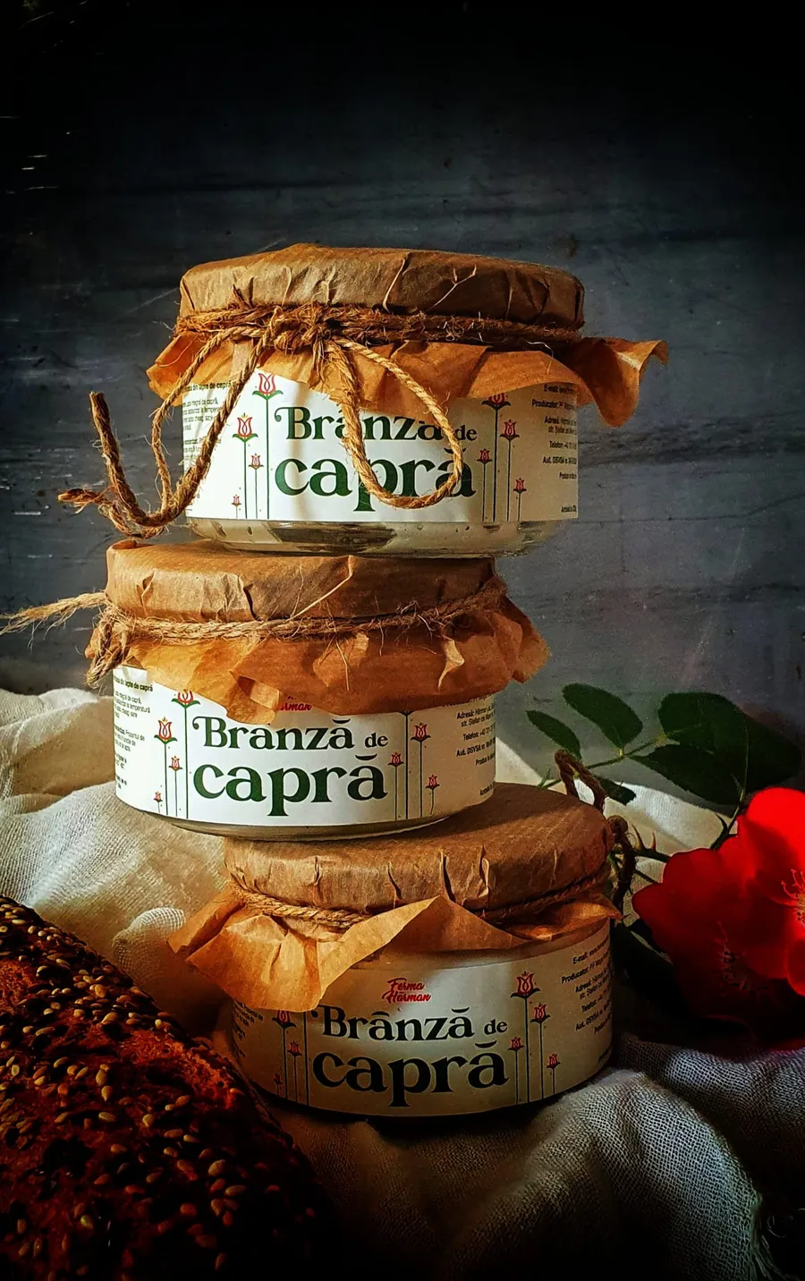 Borcane cu brânză de capră de la Ferma Hărman, expuse lângă produse de panificație. 