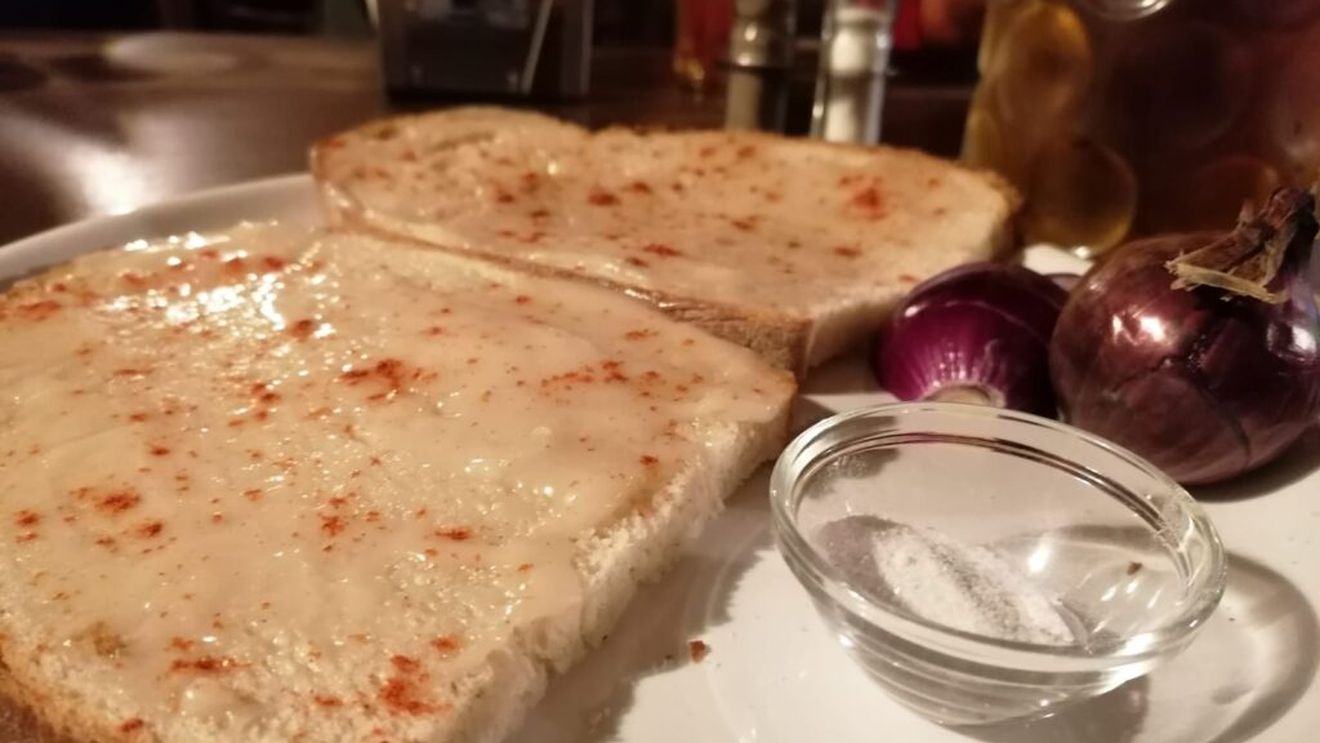 ”MÂNCAREA SĂRACULUI”, pâine cu untură de porc, ”pită cu unsoare”, în grai ardelenesc, vândută cu 23 de lei/felia la Festivalul Electric Castel, din Cluj-Napoca; de precizat că sortimentul gastronomic conține și o felie de bacon