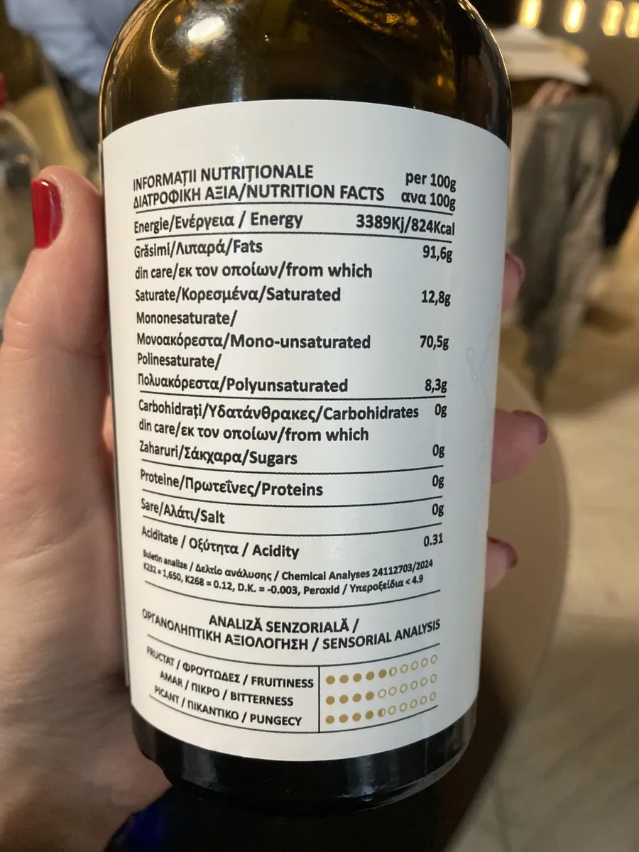 Eticheta spate a sticlei de ulei de măsline Eliada, prezentând detaliile despre varietatea măslinelor, valorile nutriționale și originea controlată a produsului.