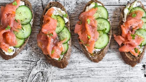 Un toast cu pâine cu secară, cremă de brânză, felii de castravete și somon afumat. O idee de mic dejun rapid și rece, de vară