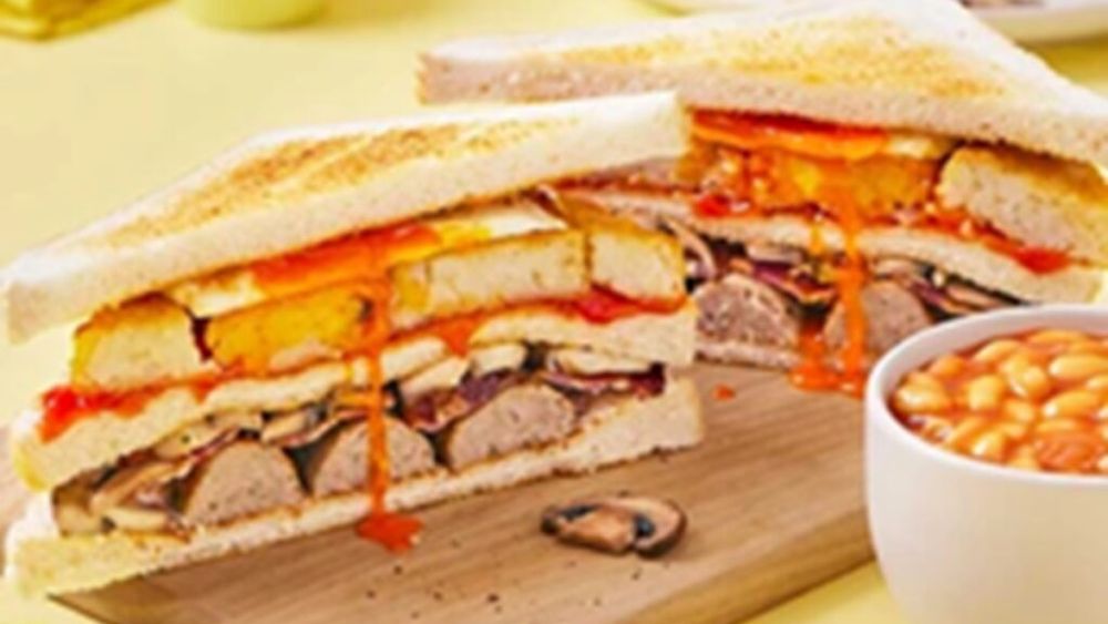 Mic dejun englezesc, complet: carnați, ou, bacon și cartofi prăjiți, între felii de pâine