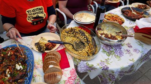 FOTO | Experiment de solidaritate: O stradă din Salonic devine anual o sufragerie comună, unde vecinii gătesc și iau masa împreună / „Am ajuns să avem aproape 400 de metri de mese și aproximativ 5.000 de participanți”