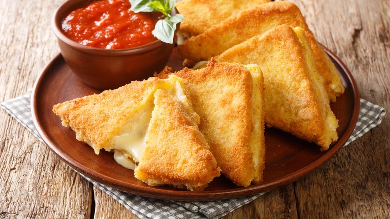 Mozzarella in carrozza, un fel de cașcaval pané 2.0. E nevoie de felii de pâine cu mozzarella între ele, date prin ou și pesmet și prăjite