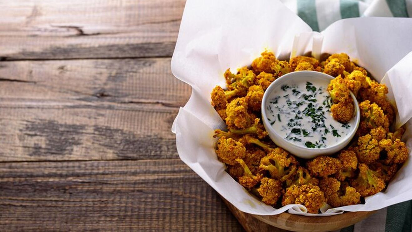 Conopidă și broccoli pané, servite cu un sos, orez simplu și salată. O idee de cină vegetariană dar cu gust