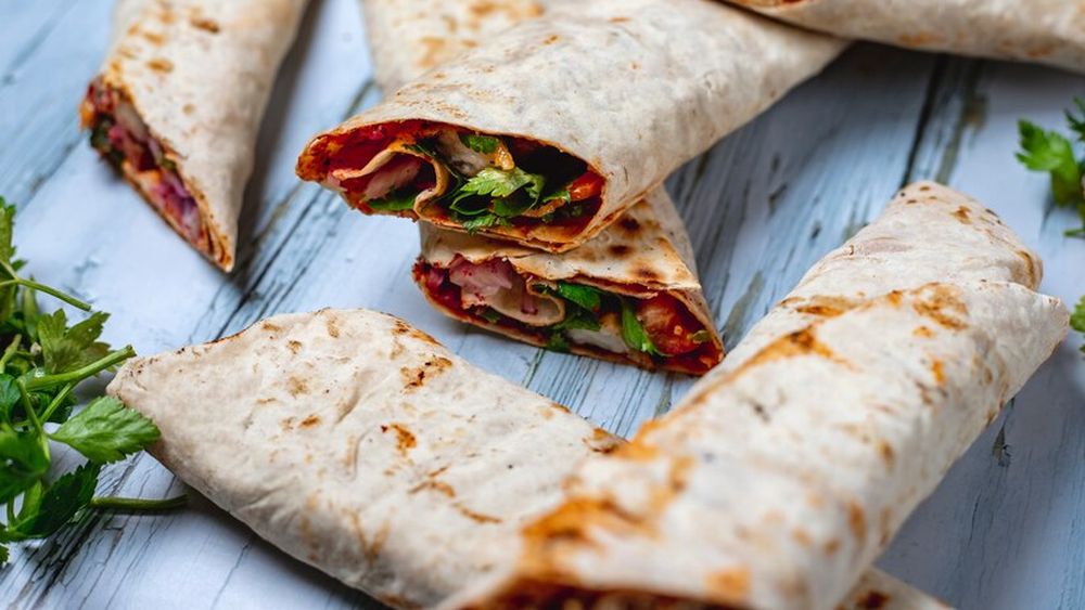 Mic dejun cu lipie și umplutură ca într-un sandviș Stromboli: salsa marinara, mozzarella și salam picant și ardei. Adică Stromboli wrap