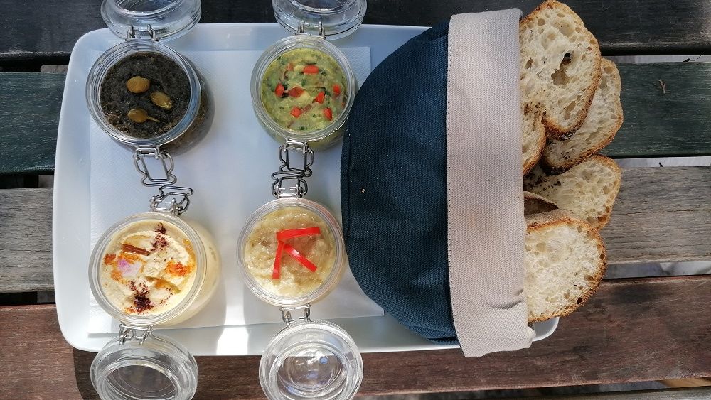 Un basarabean din Chișinău stabilit în București oferă clienților pub-ului său salată de humus, preparată cu năut din Piața Obor, după sfaturile unui bucătar american