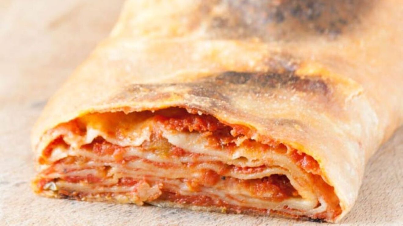 Rulouri din aluat simplu cu ceapă, sos de roșii și un strop de brânză. Scaccia ragusana, un preparat din gastronomia siciliană care se servește rece